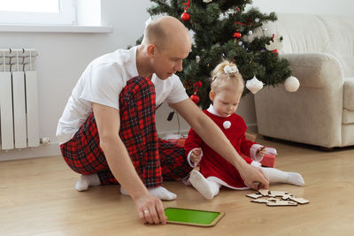 Father and daughter solving puzzle during christmas