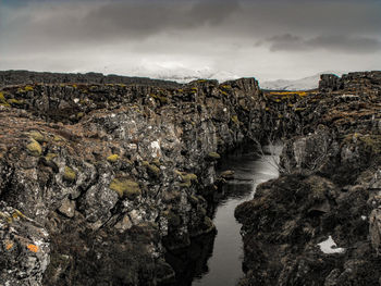 River amidst rocks against sky