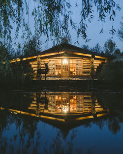 Building by lake against sky at night