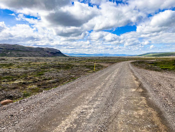 Road leading towards mountains against sky