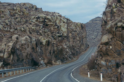 Road amidst rock formations against sky