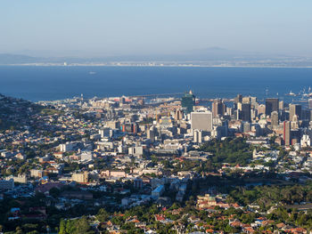 High angle view of cityscape by sea against sky