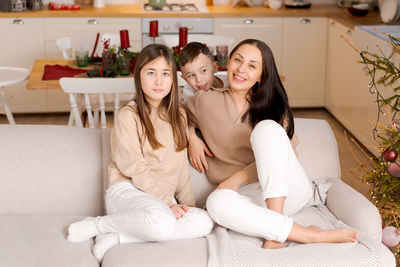 Family spends time together during christmas holidays in decorated house.