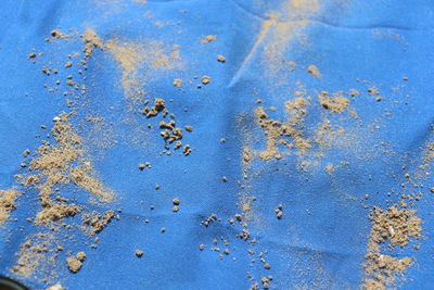 High angle view of sand on blue textile