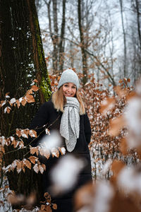 Portrait of young woman standing in winter forest