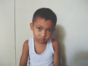 Portrait of cute boy against wall
