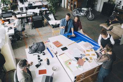 High angle view of creative businessmen and businesswomen working at table in office