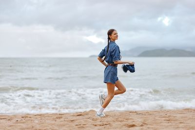 Full length of young man standing at beach