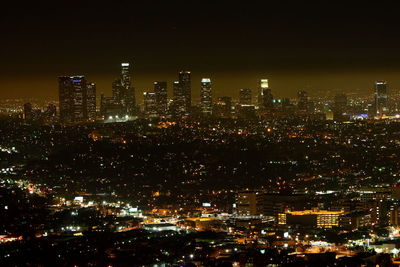Illuminated cityscape against sky at night
