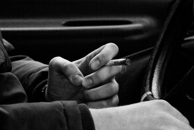 Close-up of hand holding cigarette