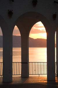 Bridge over sea against sky during sunset