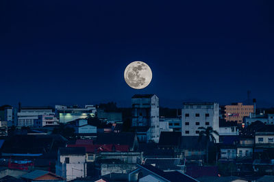 Aerial view of illuminated buildings against sky at night