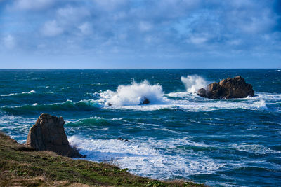 Waves of the atlantic ocean break on a rock with splashing gout on quiberon in brittany in france 