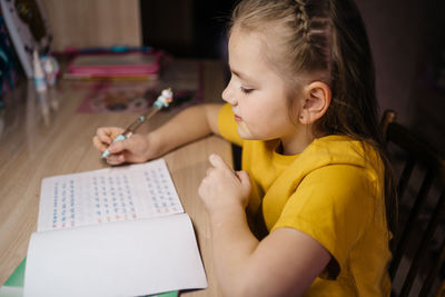 Schoolgirl does her homework. high quality photo