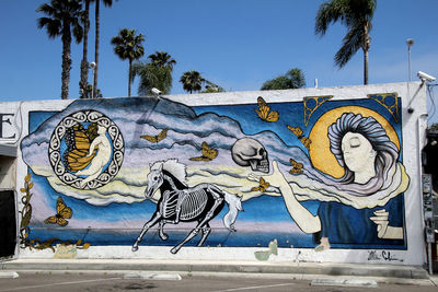 Graffiti on wall against clear blue sky