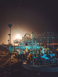 Amusement park ride against sky at night