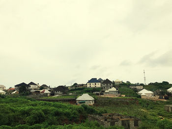 Houses by buildings against sky