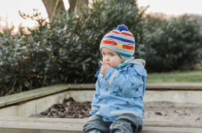 Full length of boy sitting in park