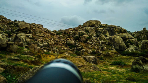 Low section of person on mountain against sky