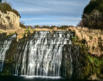 Scenic view of waterfall against sky