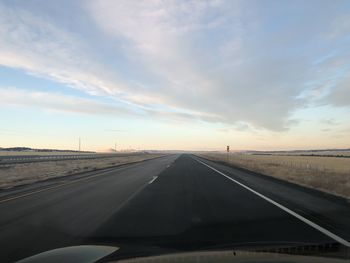 Road against sky seen through car windshield