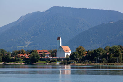 Scenic view of lake by buildings against sky