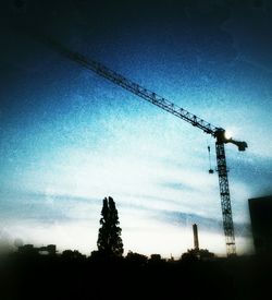 Low angle view of crane against sky