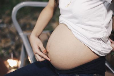 Midsection of woman sitting in park