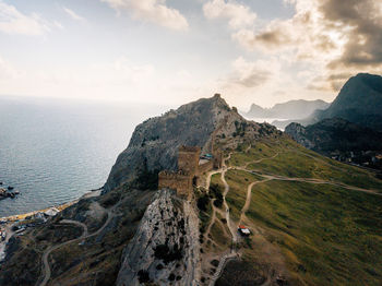 Scenic view of sea and mountains against sky