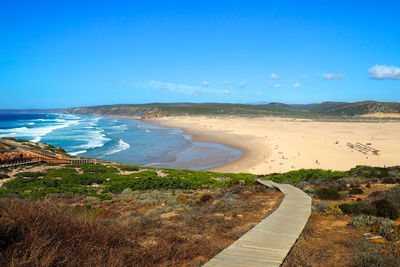 Boardwalk leading towards beach against sky