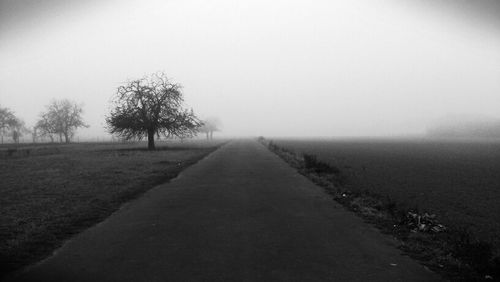 Empty road passing through field