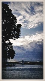 Scenic view of river against cloudy sky