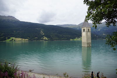 Scenic view of lake by building against sky