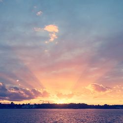 Scenic view of sea against dramatic sky during sunset