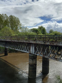 Bridge over sea against cloudy sky