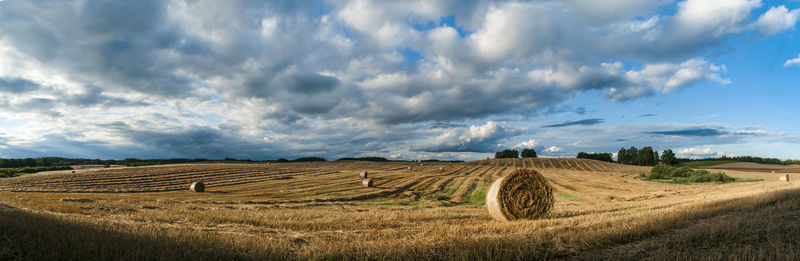 Hay bales on field against sky