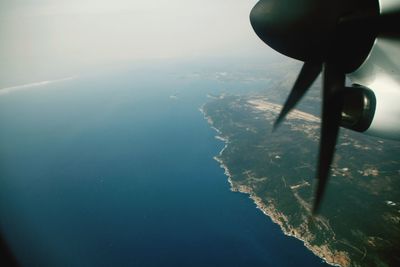 Airplane flying over sea against sky