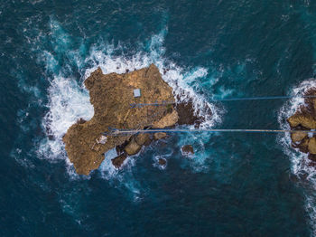 High angle view of waves splashing on rock