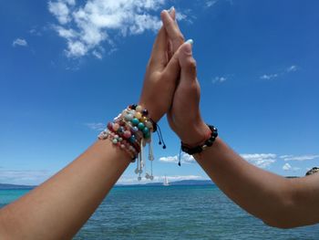 Low section of people legs against blue sky