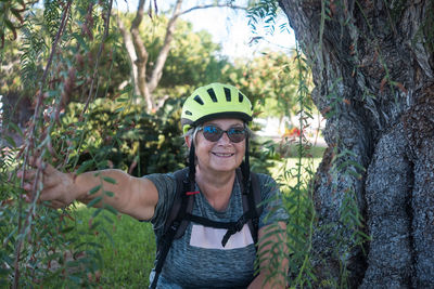 Portrait of smiling woman standing by plants