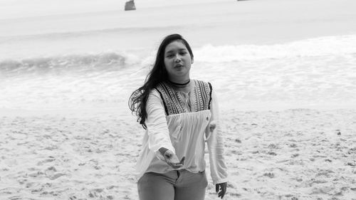 Portrait of young woman standing on beach