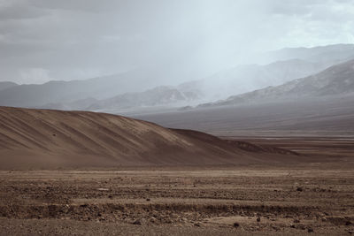 View of desert against cloudy sky