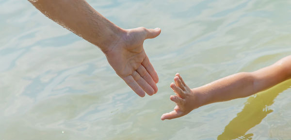 Low section of man hand on water