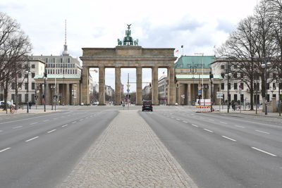 View of city street against cloudy sky