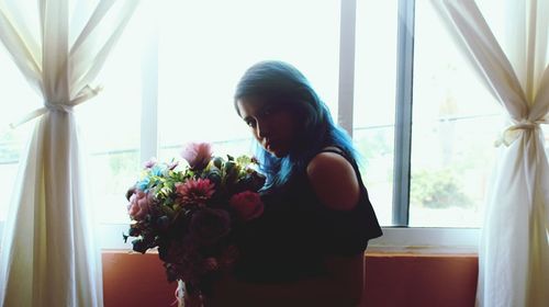 Close-up of woman standing against window