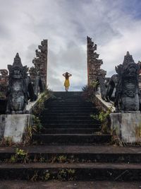 Low angle view of woman standing against sky