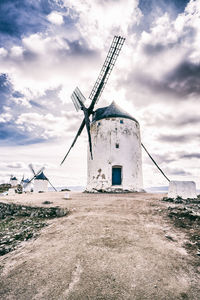 Traditional windmill on field against sky