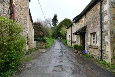 Road amidst houses against sky