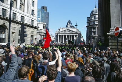 People on street against buildings in city