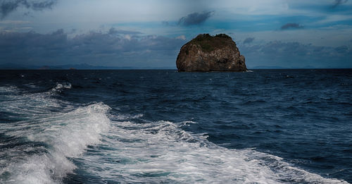 Scenic view of rocks in sea against sky